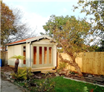 Traditional garden log cabin with glazing to the front face.  Pitch roof, used as a garden office. Gallery Thumbnail