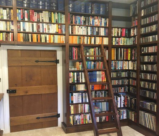 Floor to ceiling stained pine shelving for books, CD/DVD and records with bespoke moveable ladder. Gallery Image