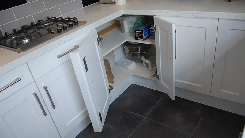 White painted shaker style kitchen with easy access corner cabinet. Gallery Image