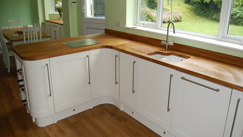 Bespoke Ivory Shaker style kitchen with curved doors and Oak worktops. Gallery Image