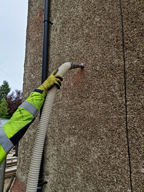 Installing insulation into the wall cavity. Gallery Image